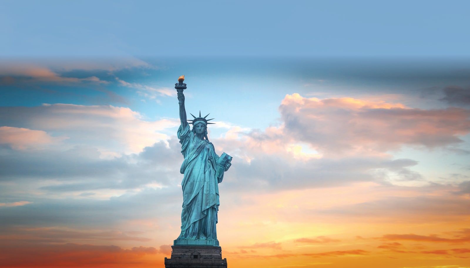 The Statue of Liberty against a sunset sky